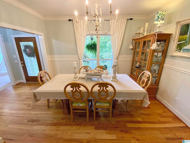 dining space featuring ornamental molding, a notable chandelier, and wood-type flooring