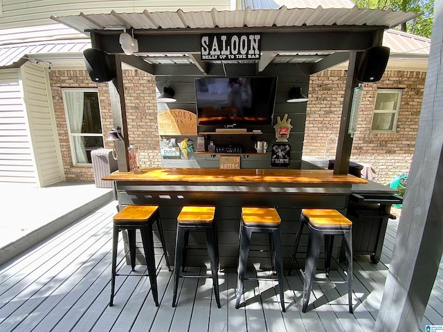 bar featuring hardwood / wood-style floors and brick wall