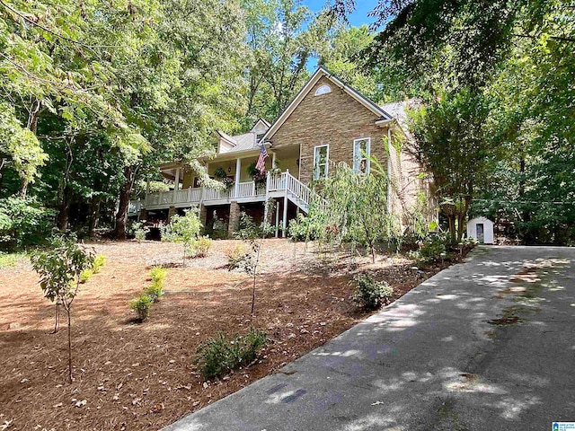 view of front of house featuring a porch and an outbuilding