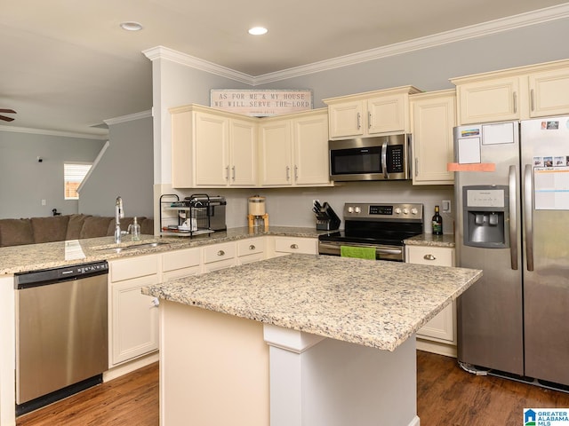 kitchen featuring crown molding, dark wood-type flooring, stainless steel appliances, sink, and cream cabinetry