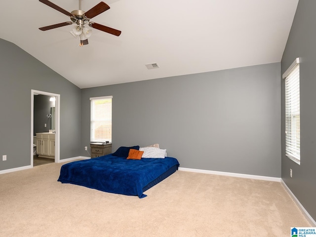 carpeted bedroom featuring lofted ceiling, ensuite bathroom, and ceiling fan