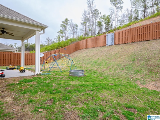 view of yard with ceiling fan and an outdoor fire pit