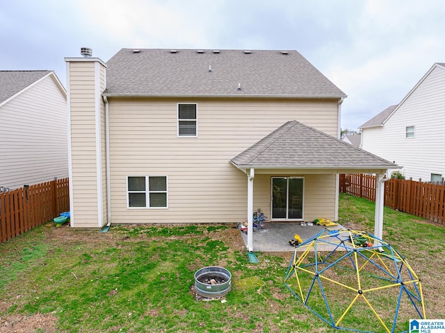 rear view of property with a lawn, a patio, and a fire pit