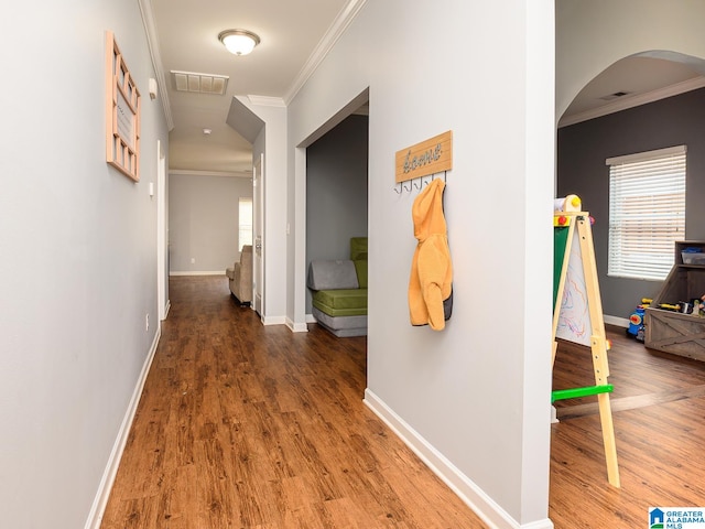 hall with ornamental molding and hardwood / wood-style floors