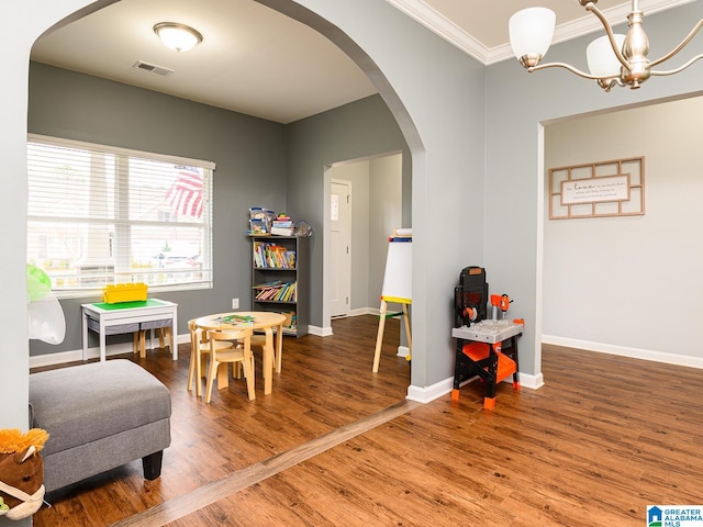 sitting room featuring ornamental molding, a notable chandelier, and wood-type flooring