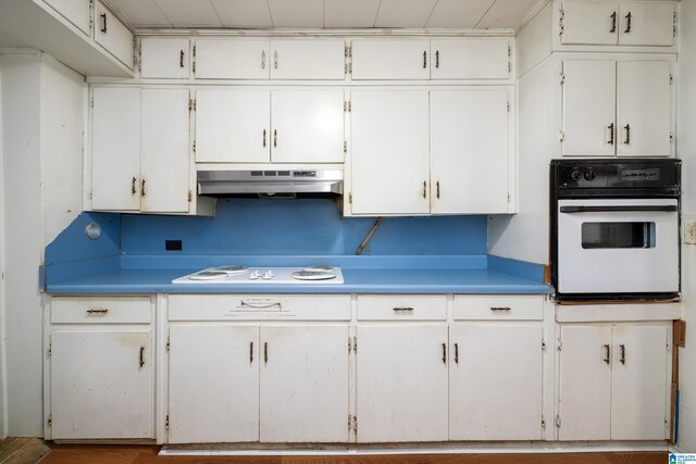 kitchen featuring hardwood / wood-style floors, white appliances, and white cabinetry