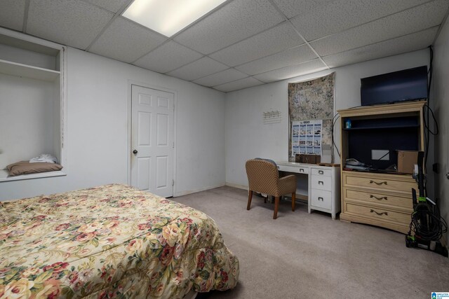 bedroom featuring light colored carpet and a drop ceiling