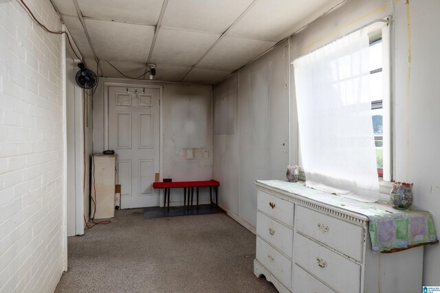 interior space with brick wall and light carpet