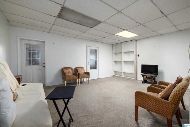 carpeted living room with a drop ceiling