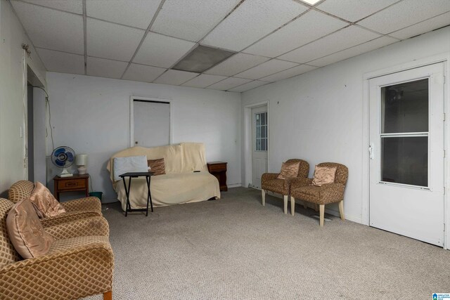 carpeted living room featuring a paneled ceiling