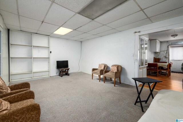 living room featuring a paneled ceiling and hardwood / wood-style flooring