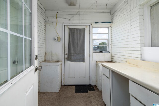 bathroom featuring brick wall and wooden walls