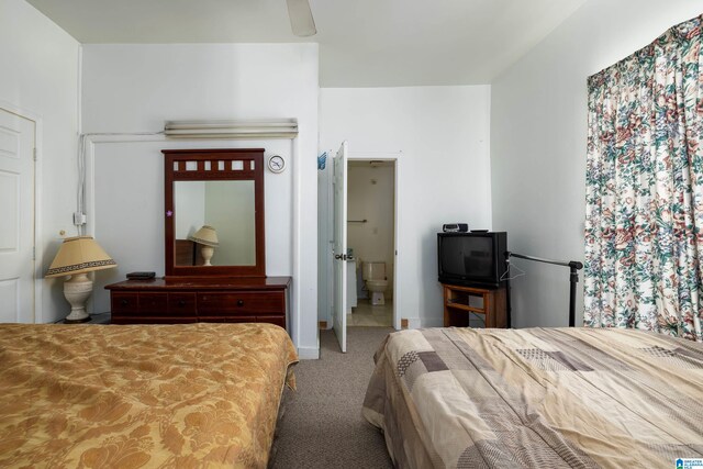 carpeted bedroom with ensuite bath and ceiling fan