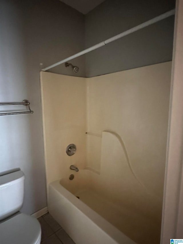 bathroom with shower / bathing tub combination, toilet, and tile patterned floors