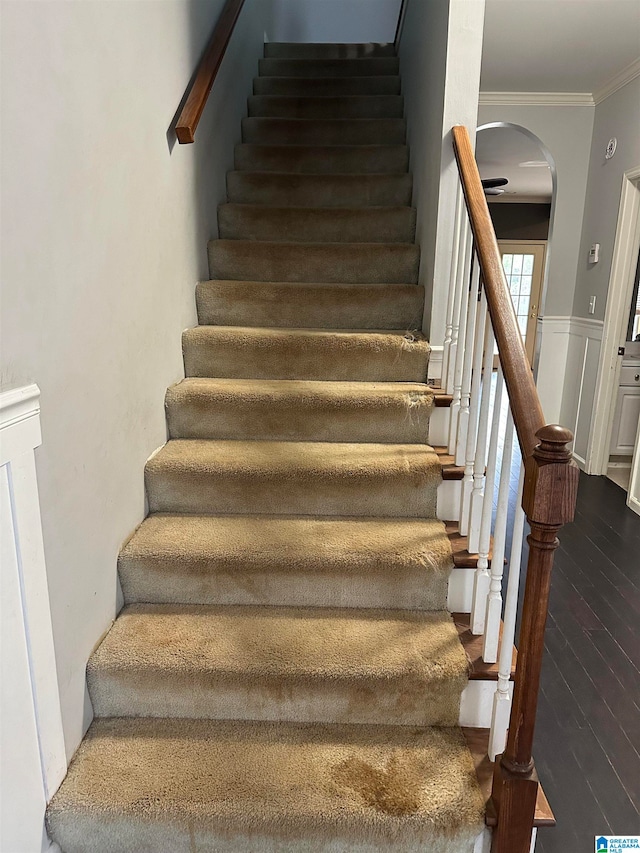 stairs featuring crown molding and hardwood / wood-style floors