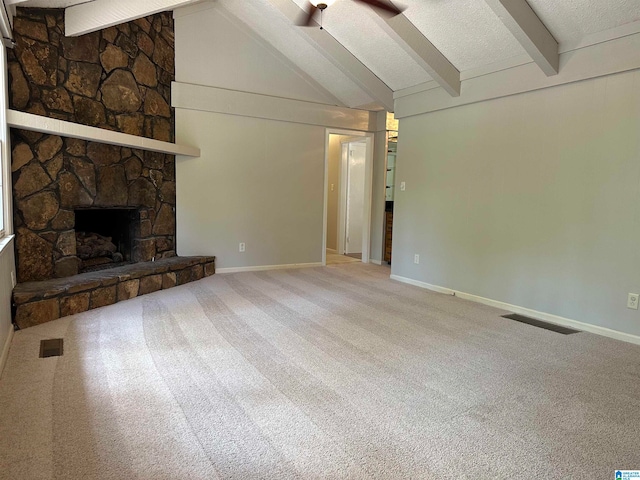 unfurnished living room with carpet, lofted ceiling with beams, ceiling fan, a fireplace, and a textured ceiling