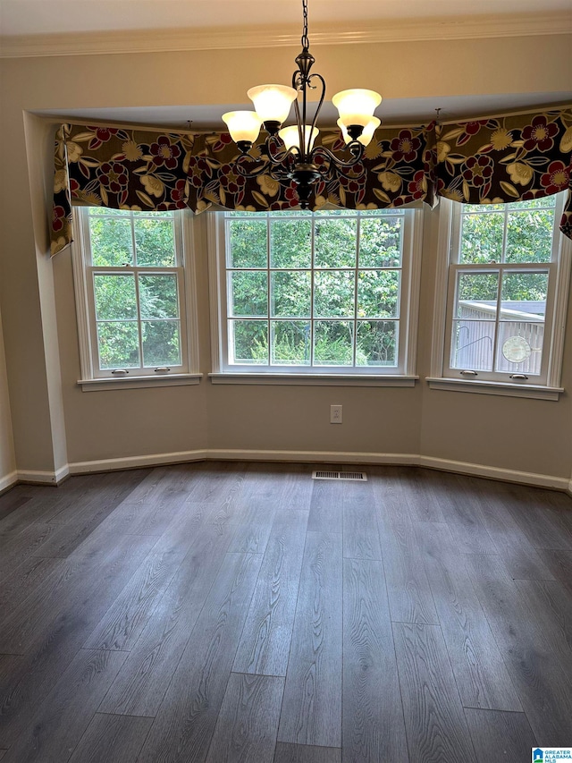 unfurnished dining area featuring ornamental molding, a wealth of natural light, and a chandelier