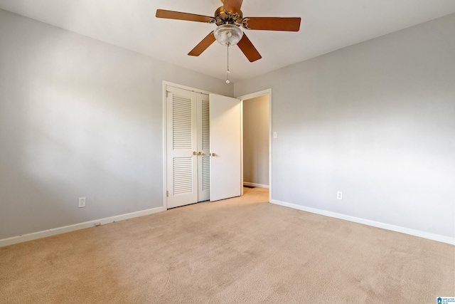 spare room featuring light carpet and ceiling fan