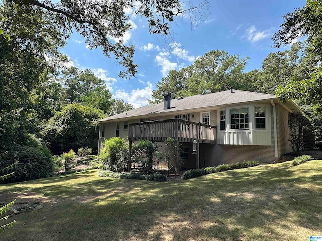 rear view of property featuring a yard and a wooden deck