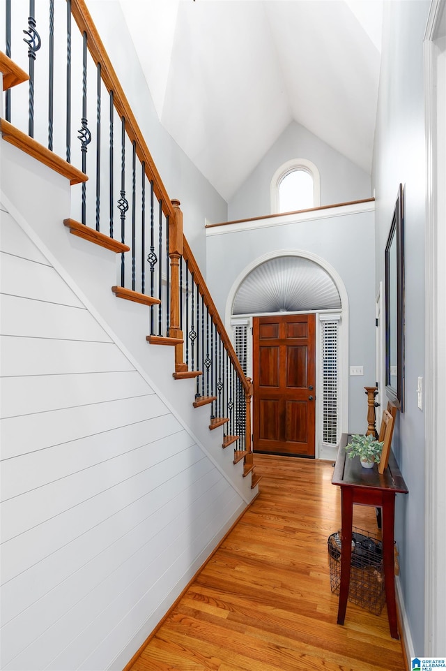 entrance foyer with light wood-type flooring and high vaulted ceiling