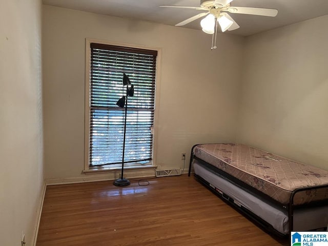 unfurnished bedroom with visible vents, ceiling fan, baseboards, and wood finished floors