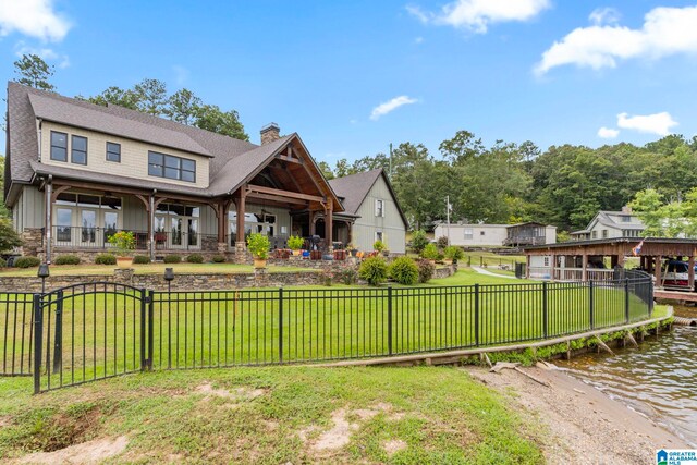 exterior space with a water view, a front lawn, and covered porch