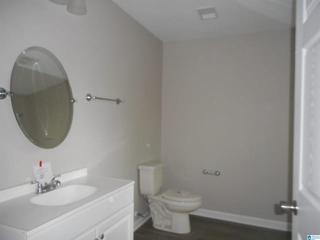 bathroom with wood-type flooring, toilet, and vanity