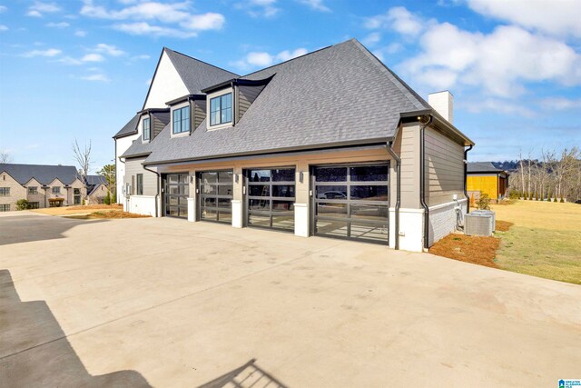 view of property exterior featuring cooling unit, a garage, and a yard