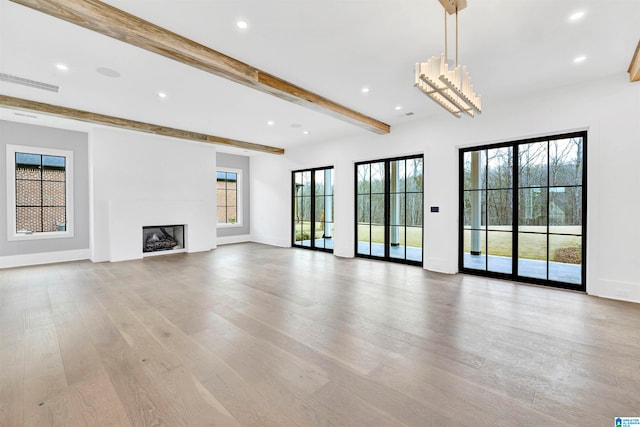 unfurnished living room with light hardwood / wood-style flooring and beam ceiling