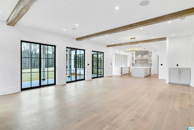 unfurnished living room with light hardwood / wood-style flooring and beam ceiling