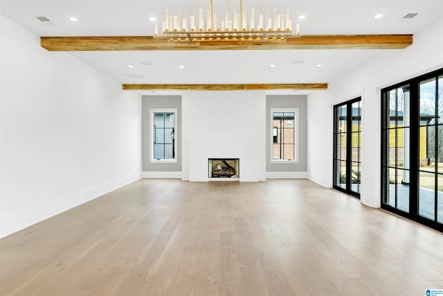 unfurnished living room featuring light hardwood / wood-style floors, beamed ceiling, and french doors