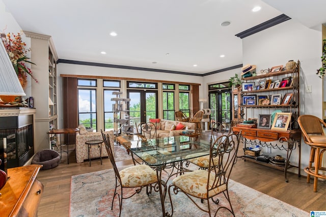 dining space with wood-type flooring, crown molding, and french doors