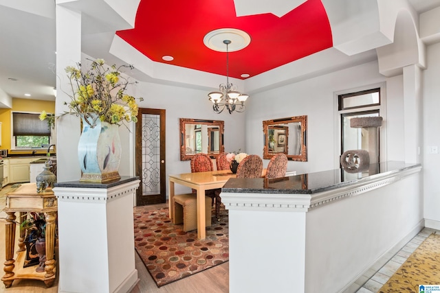 kitchen with kitchen peninsula, a wealth of natural light, hanging light fixtures, and a notable chandelier