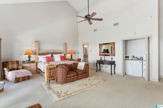 bedroom featuring ceiling fan, ensuite bathroom, high vaulted ceiling, and light carpet