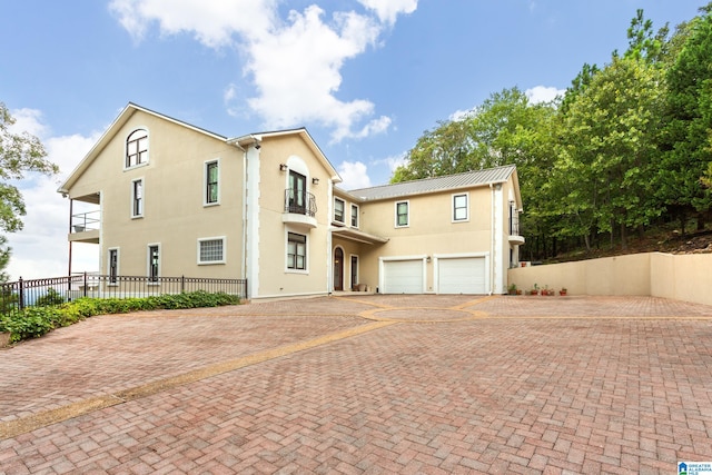 view of front of property featuring a balcony and a garage