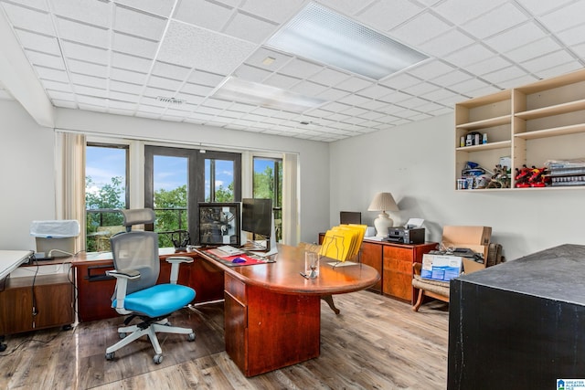 office space featuring french doors, hardwood / wood-style flooring, and a drop ceiling