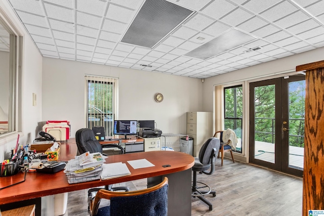 office featuring french doors, a paneled ceiling, and light hardwood / wood-style floors