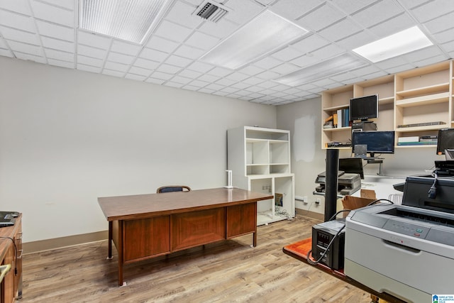 home office featuring light wood-type flooring and a drop ceiling