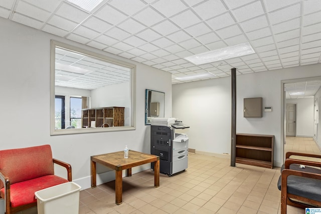 sitting room with a drop ceiling and light tile patterned flooring