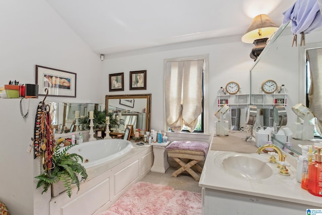 bathroom with a washtub, vanity, and lofted ceiling