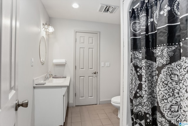 bathroom with tile patterned flooring, vanity, and toilet