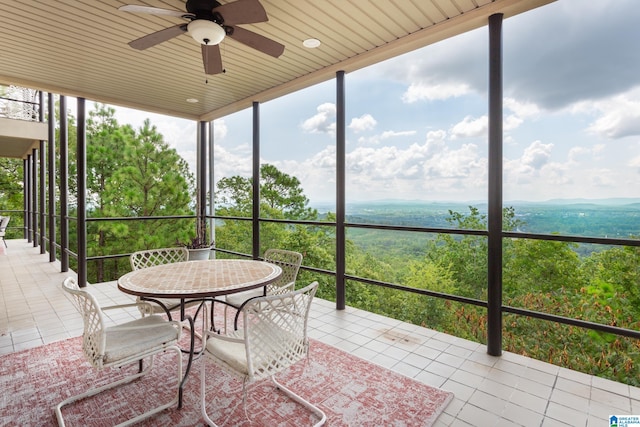 unfurnished sunroom featuring ceiling fan