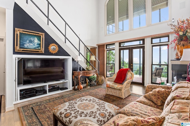 living room with a wealth of natural light, a high ceiling, and hardwood / wood-style flooring