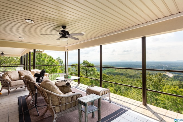 sunroom with ceiling fan and wood ceiling