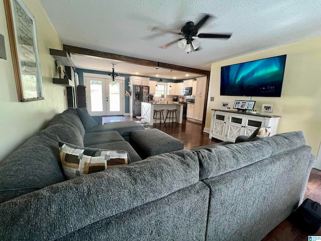 living room featuring a textured ceiling, dark wood-type flooring, ceiling fan, and french doors