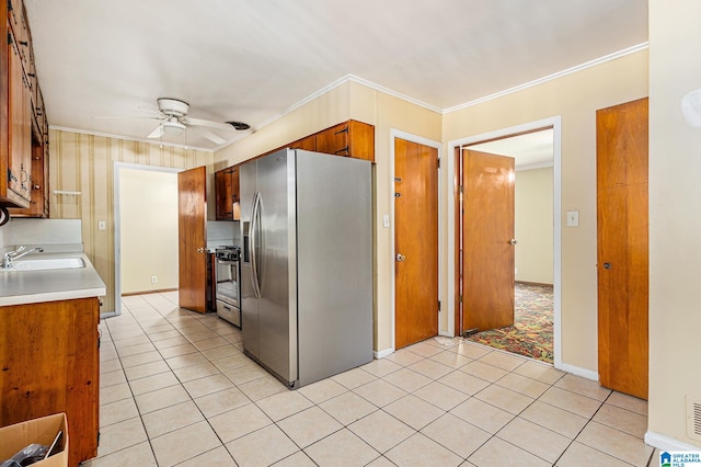 kitchen featuring crown molding, sink, ceiling fan, appliances with stainless steel finishes, and light tile patterned flooring