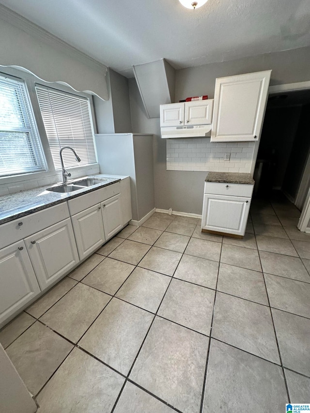 kitchen featuring light tile patterned floors, white cabinetry, sink, and decorative backsplash