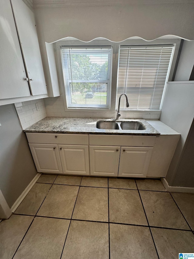 kitchen featuring white cabinets, light tile patterned flooring, tasteful backsplash, and sink