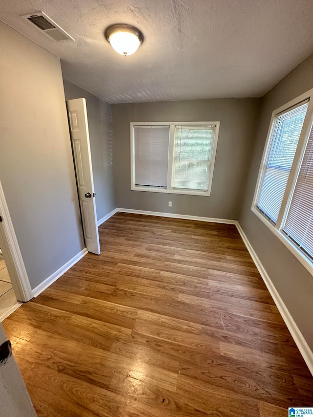 unfurnished room featuring a textured ceiling and hardwood / wood-style flooring