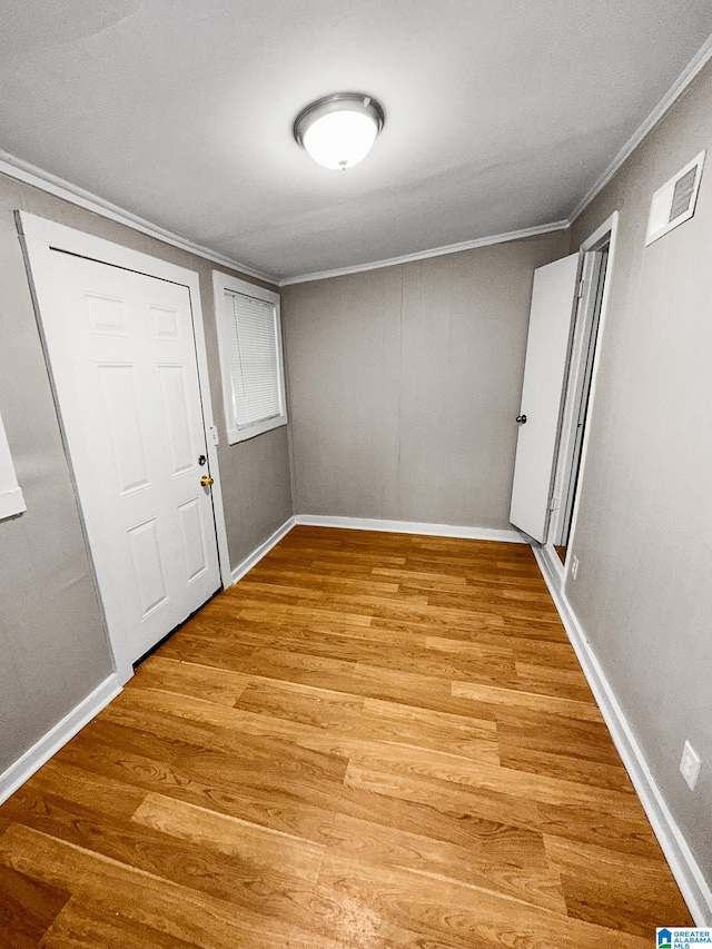 foyer entrance featuring ornamental molding and light hardwood / wood-style flooring